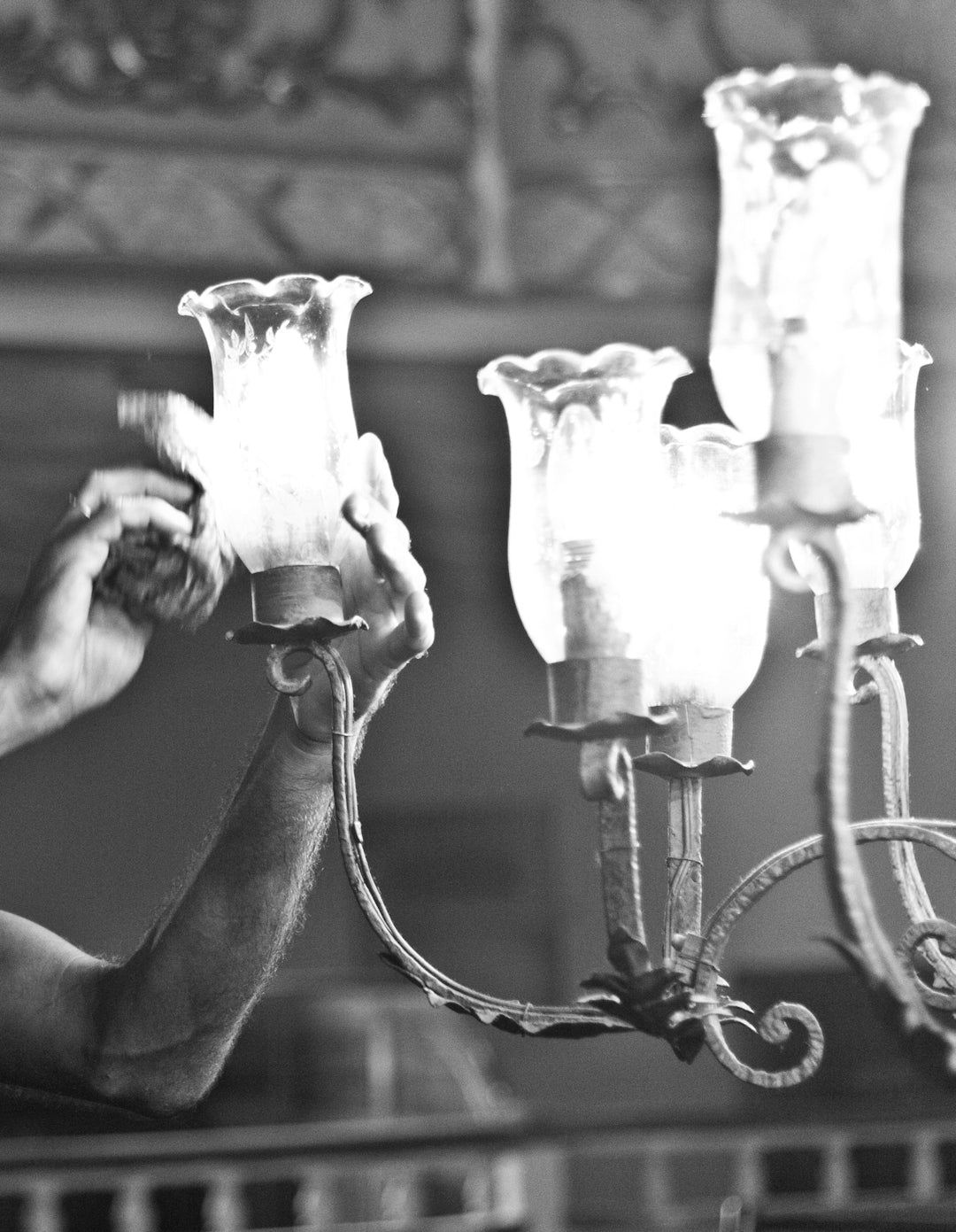Picture showing man cleaning a chandelier