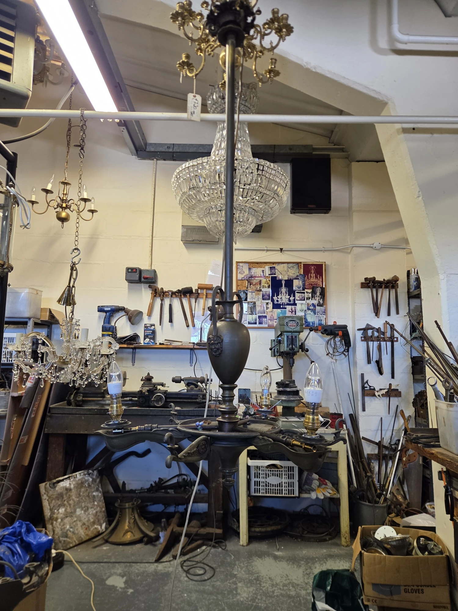 Antique gasolier rewired in the G & P Cohn workshop with new BC lampholders and bulbs before shade installation.