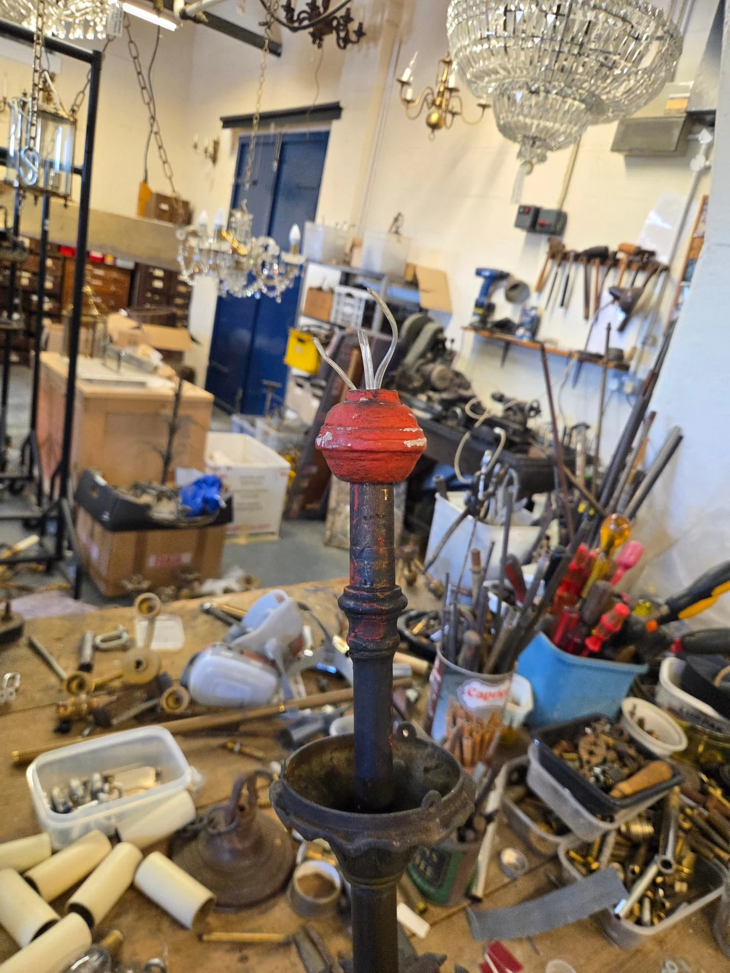 Original gas-pipe ceiling connection on an antique gasolier before conversion to a brass hanging hook.