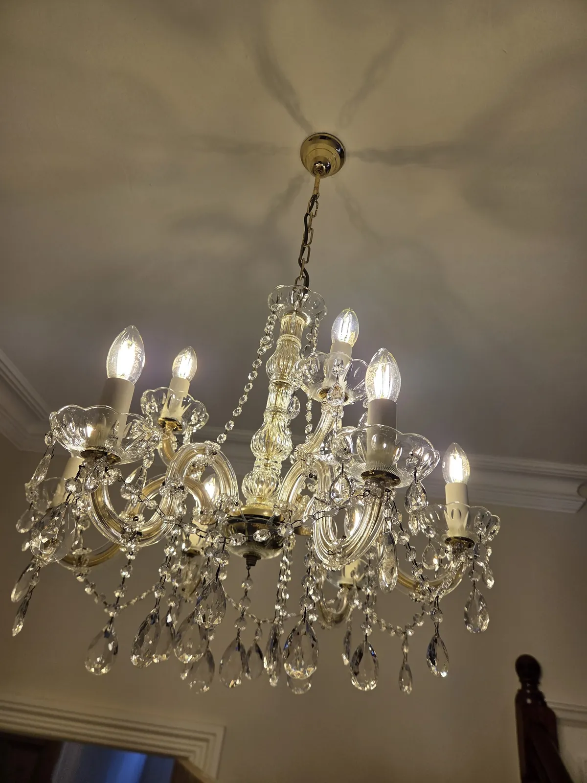 Close-up of glass arms and crystal drops on a restored Maria Theresa chandelier.