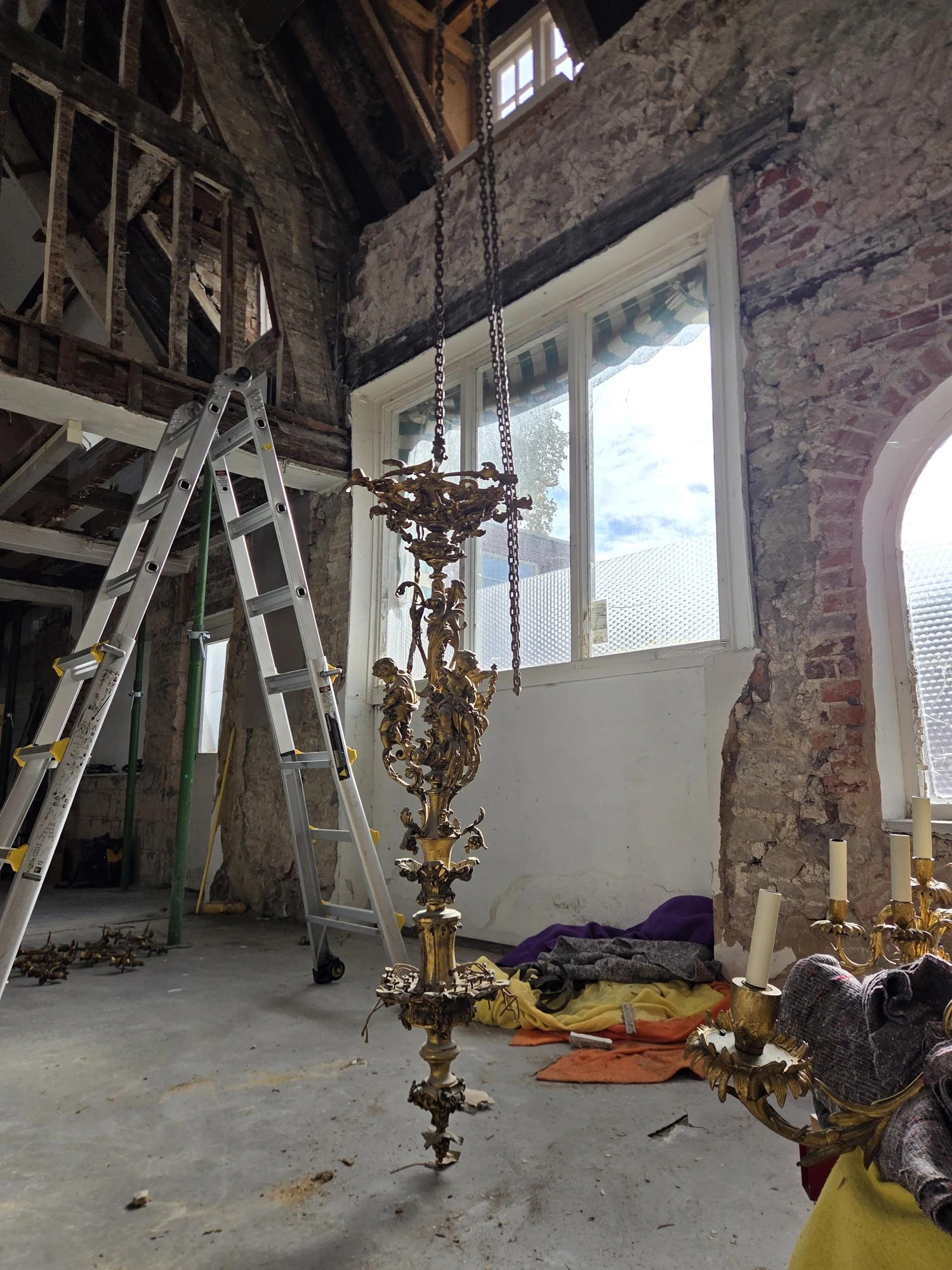 Full length of the chandelier's remaining central stem with its sculptural gilt decoration.
