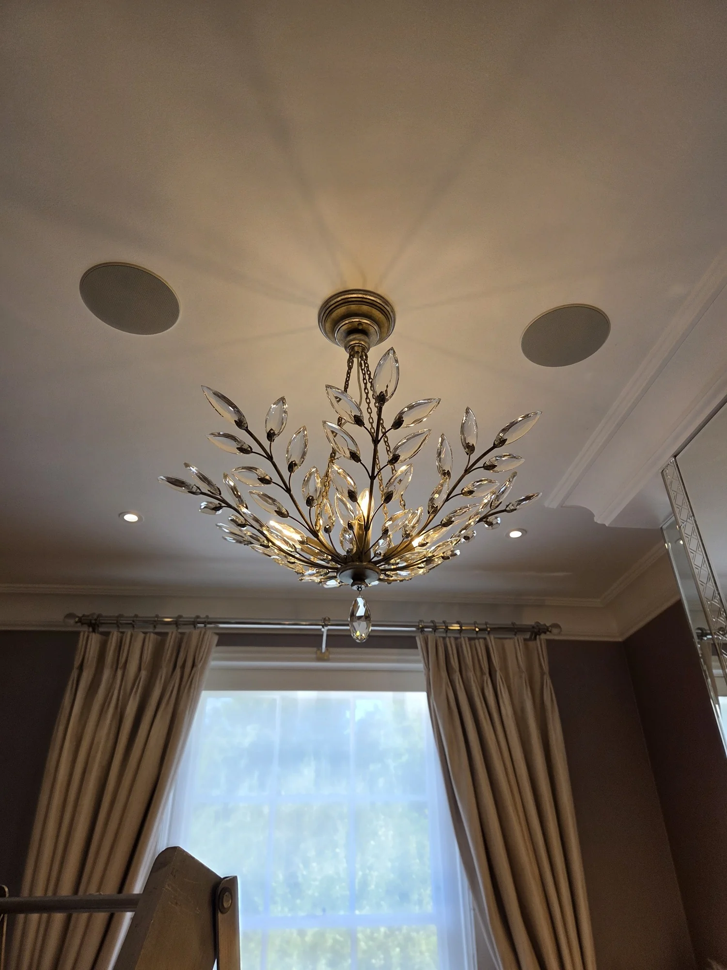 Glass leaf chandelier hanging beneath its ceiling rose in a room at The Boltons, London.