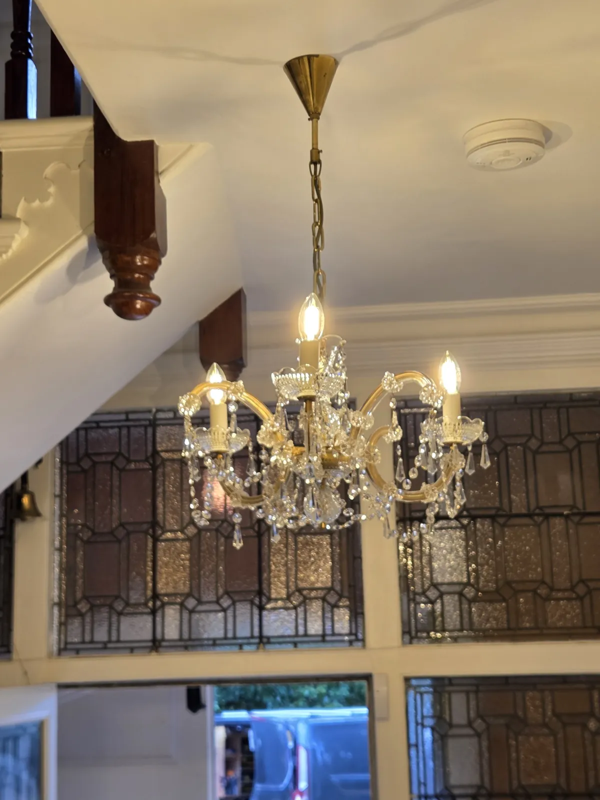 Restored Maria Theresa chandelier illuminated and rehung in an Ascot residence.