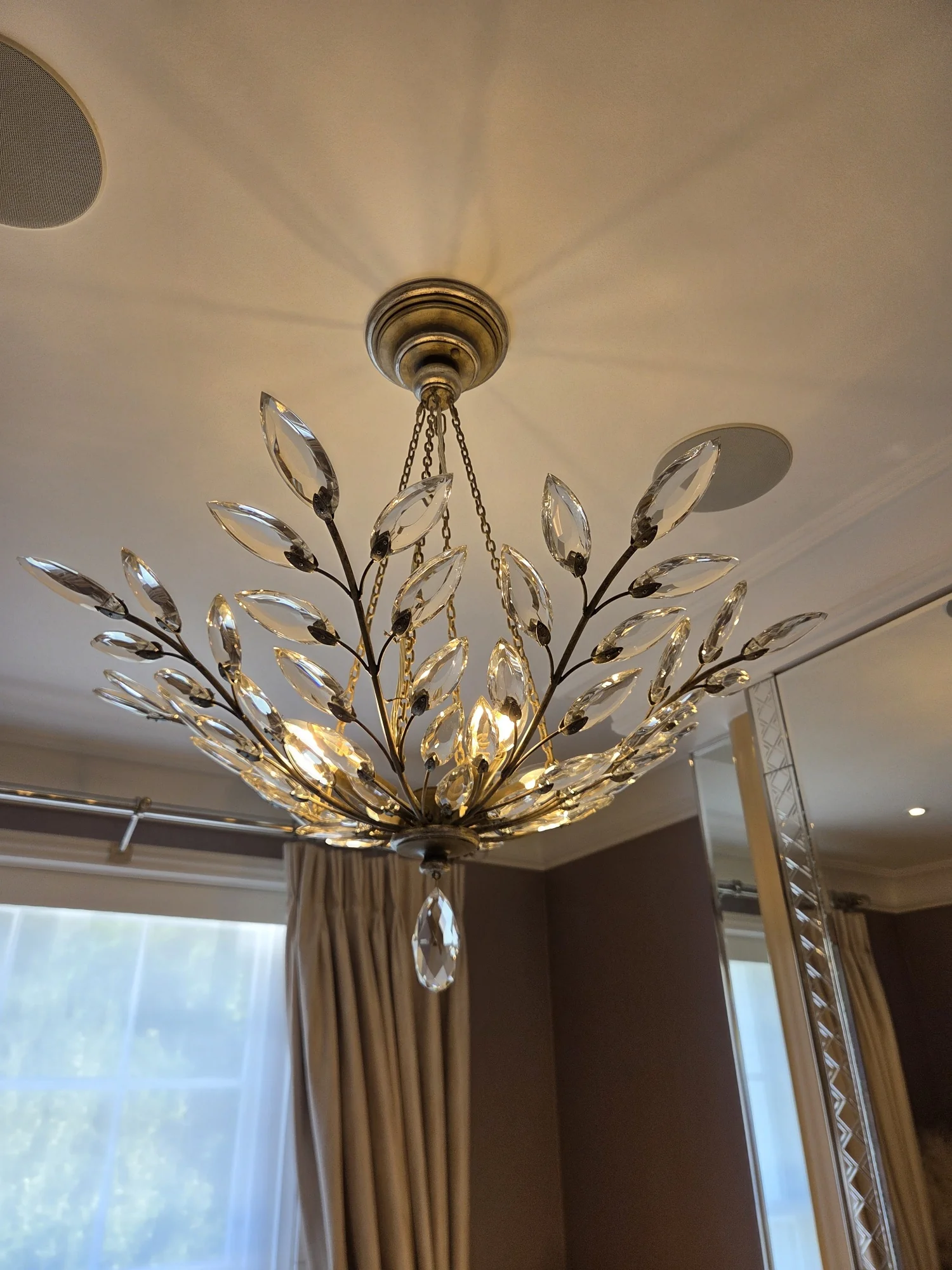 Illuminated glass leaf chandelier with suspension chains at a private residence in The Boltons, London.