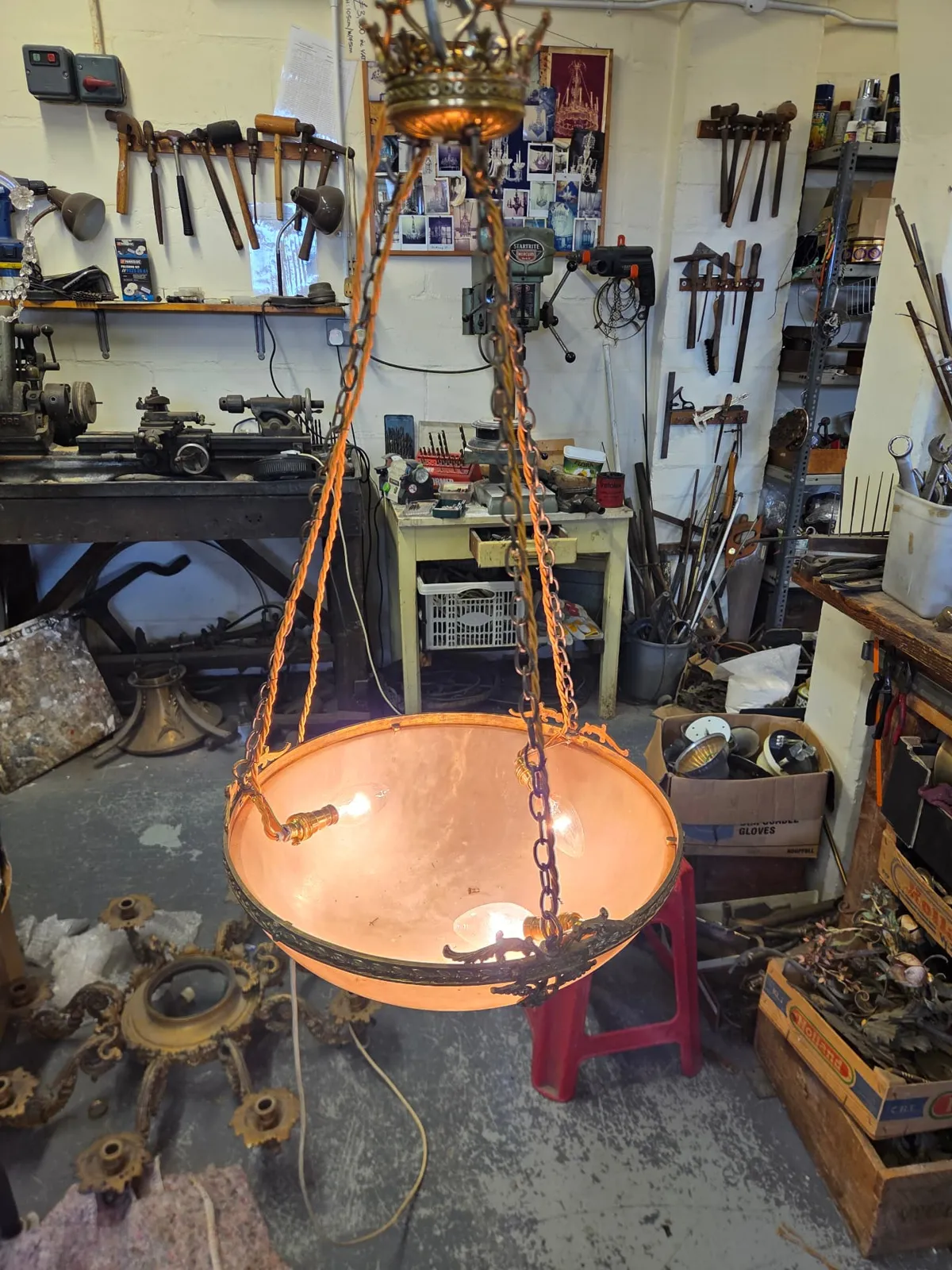 Alabaster chandelier undergoing three-light electrification and suspension modification at the G & P Cohn workshop.