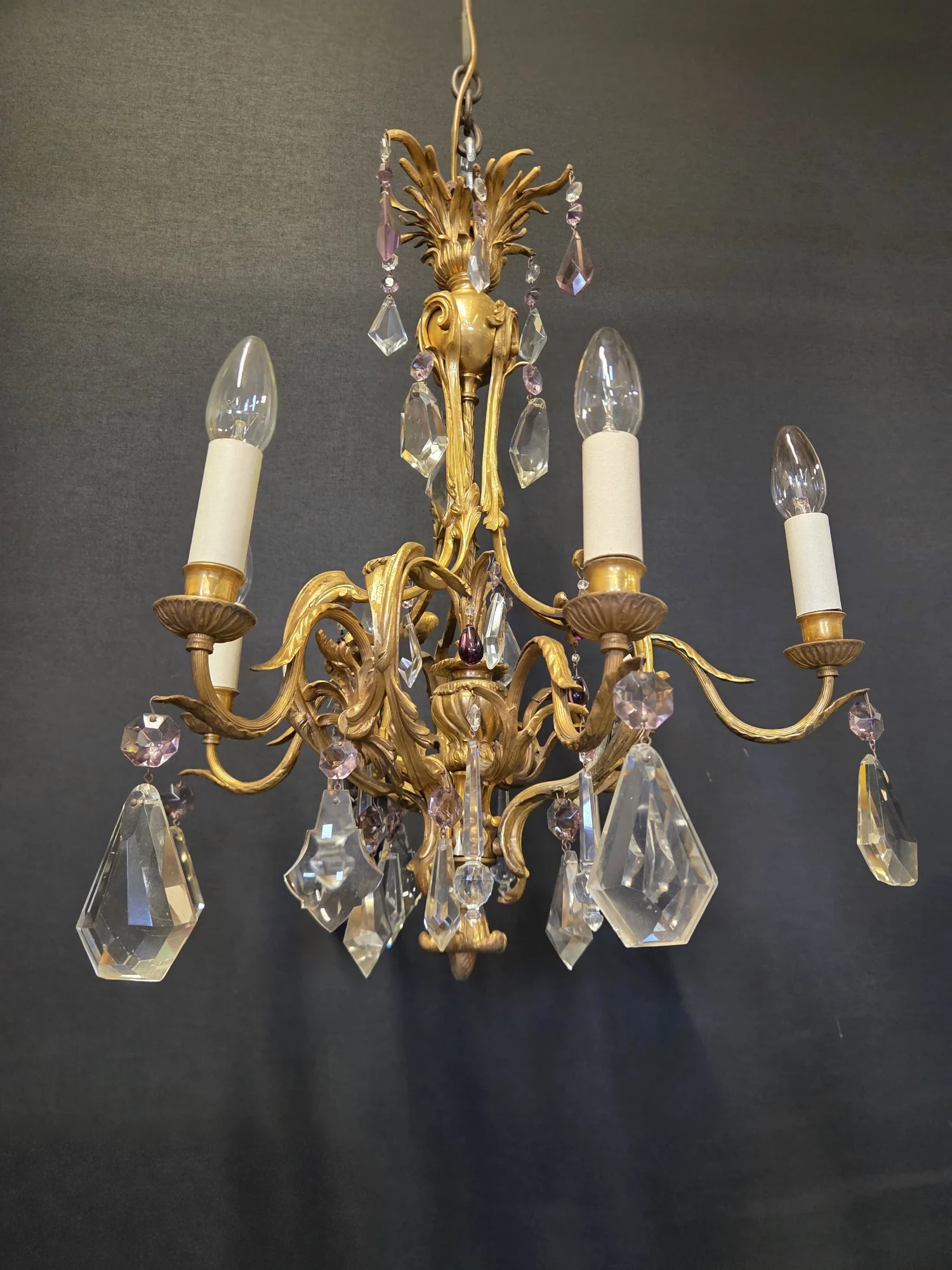 Side view of the French ormolu chandelier showing the scrolling arms, candle pans and diamond-shaped drops