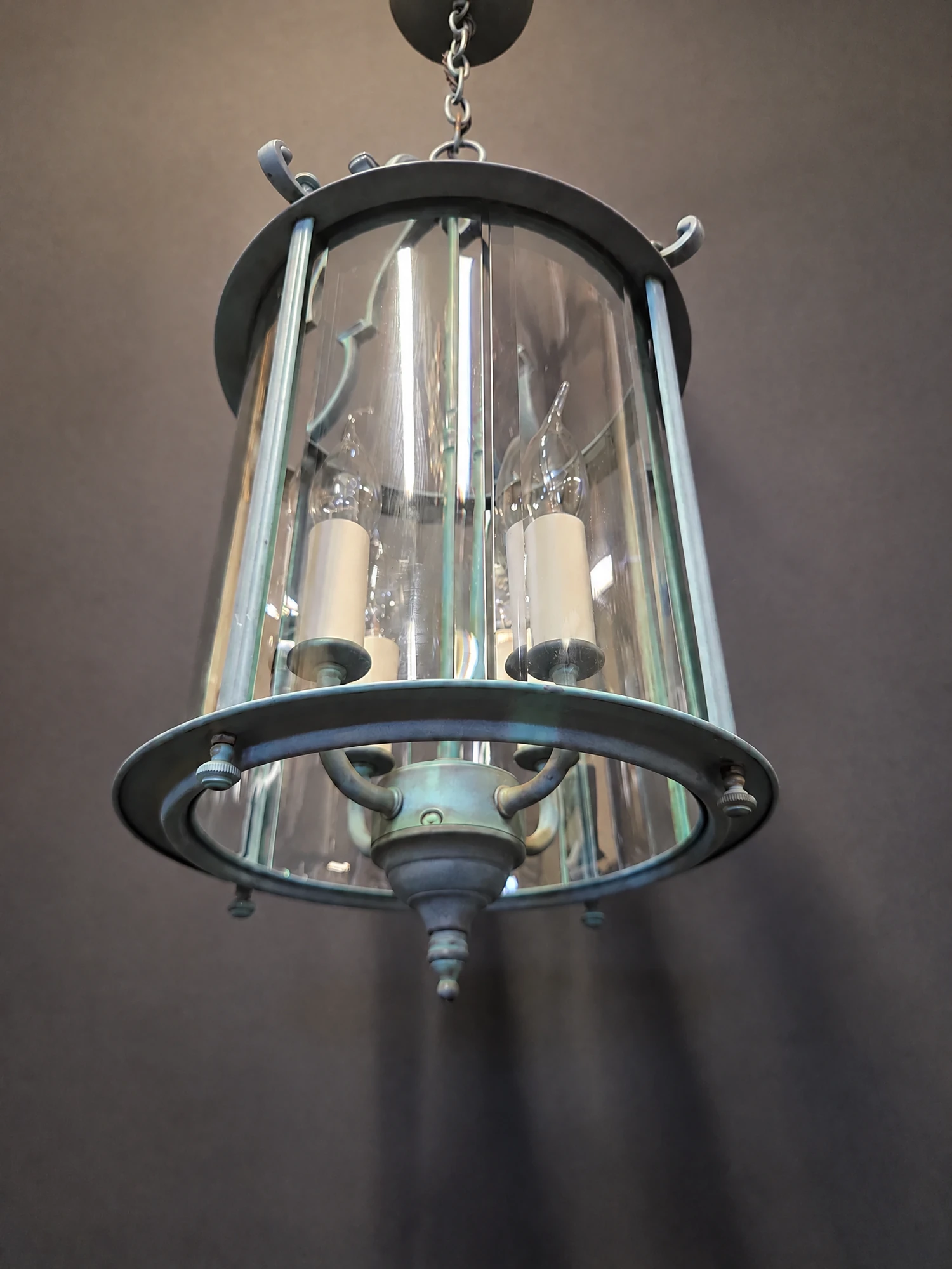 Close-up of the curved bevelled glass panels and candle tubes of the round green lantern
