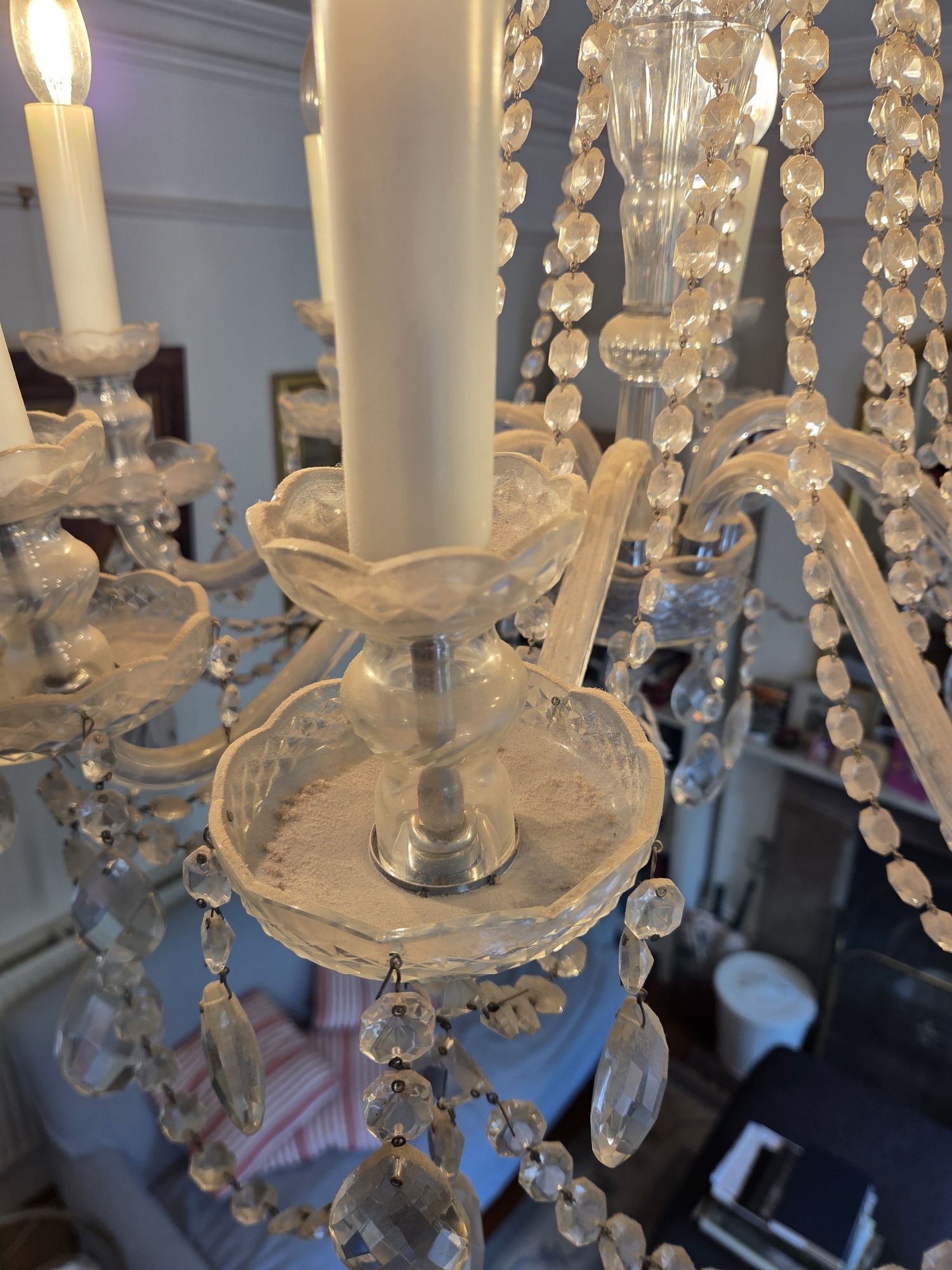 Dust on a glass candle cup and hanging drops before cleaning.
