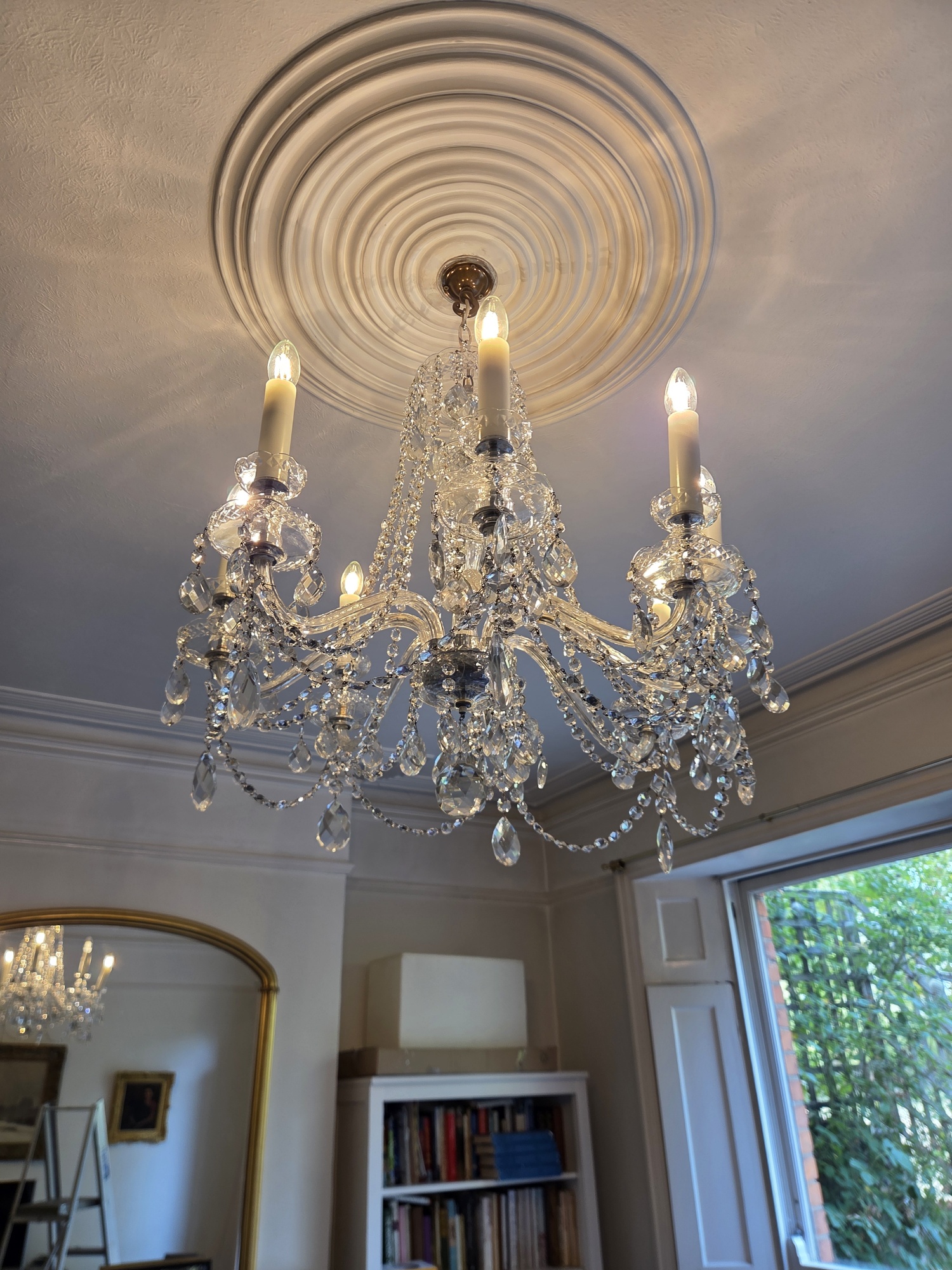 Cleaned eight-arm Czech chandelier illuminated in the Hackney property.