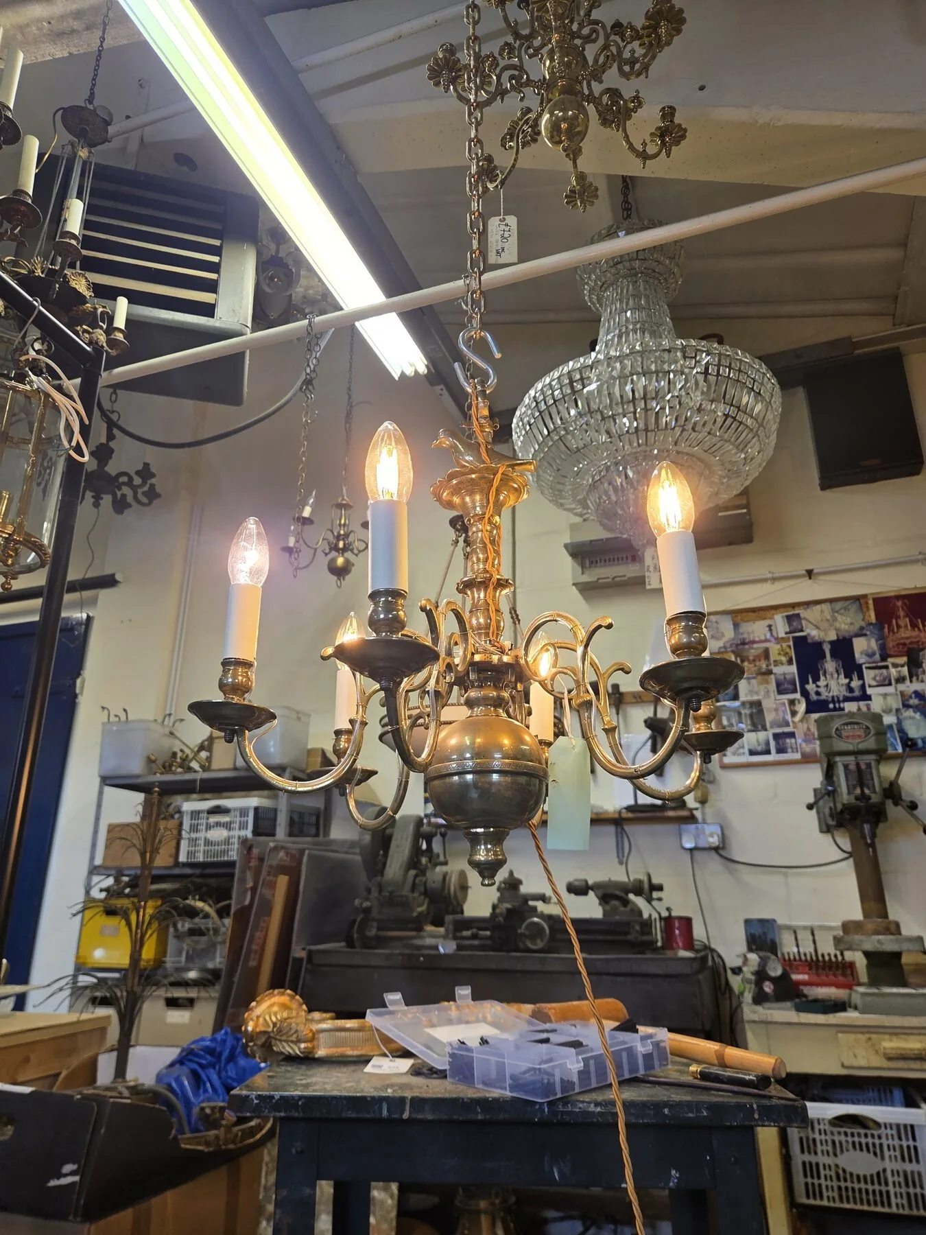 The chandelier illuminated after rewire, tested on the workshop suspension