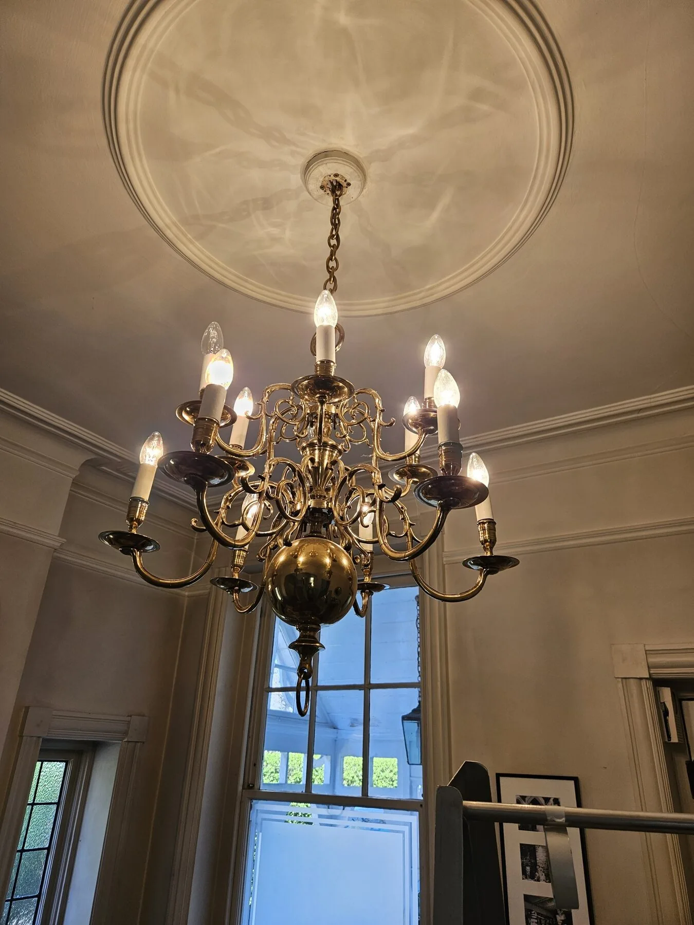 Dutch brass chandelier fully lit in the reception room of a South West London residence
