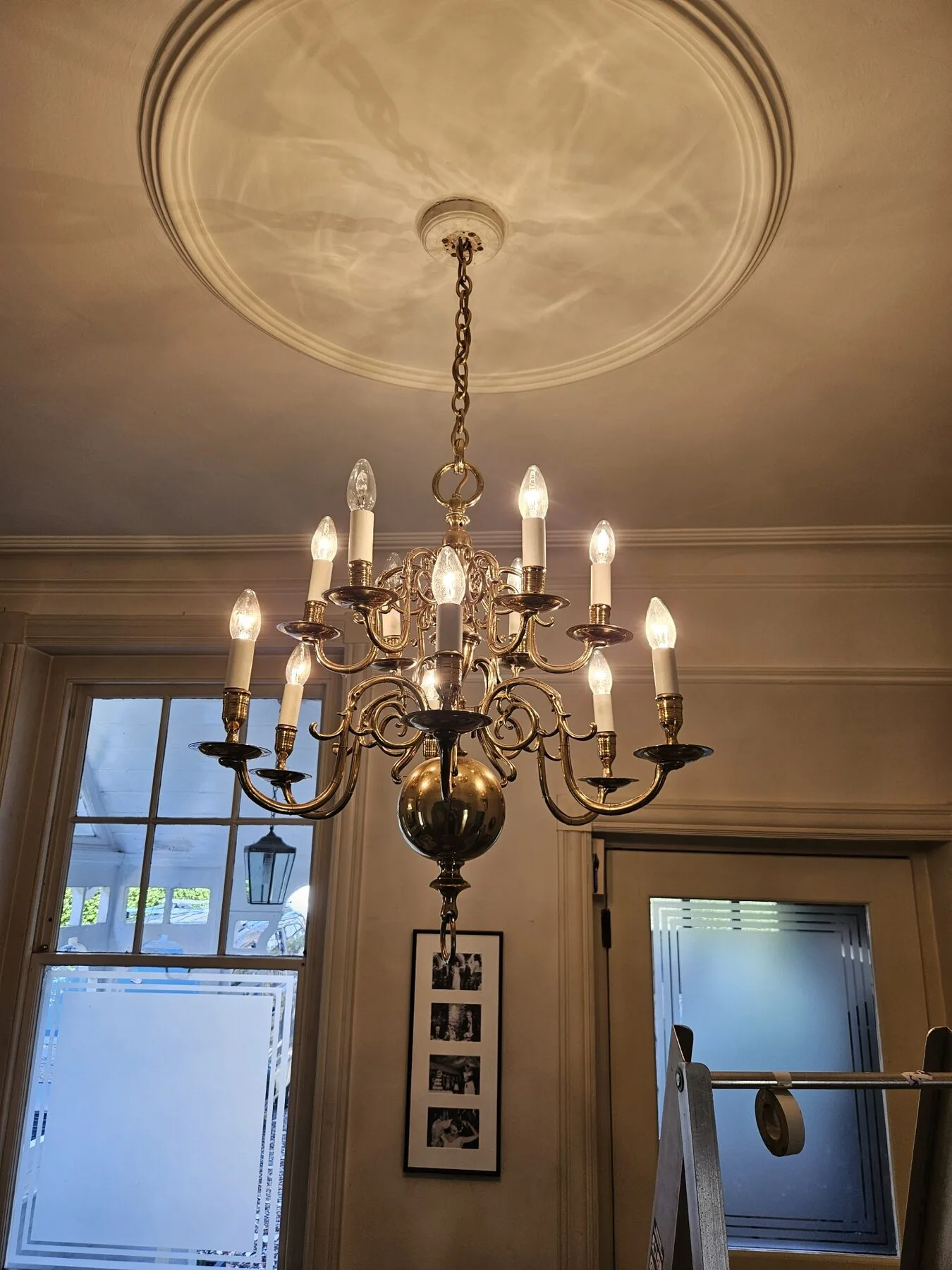 Two-tier Dutch brass chandelier lit and levelled in the South West London reception room