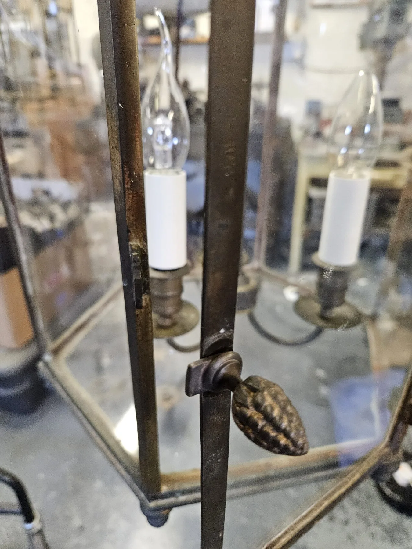 Close view of the door mechanism and replacement pine-cone finial