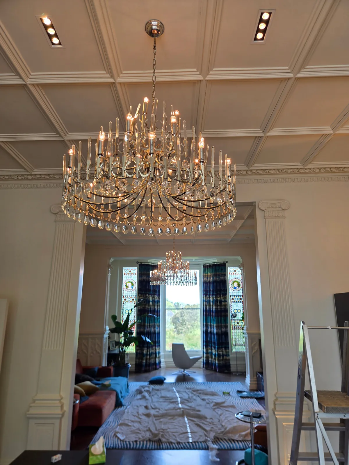Large contemporary glass chandelier suspended at high level in Hampstead, London, before cleaning