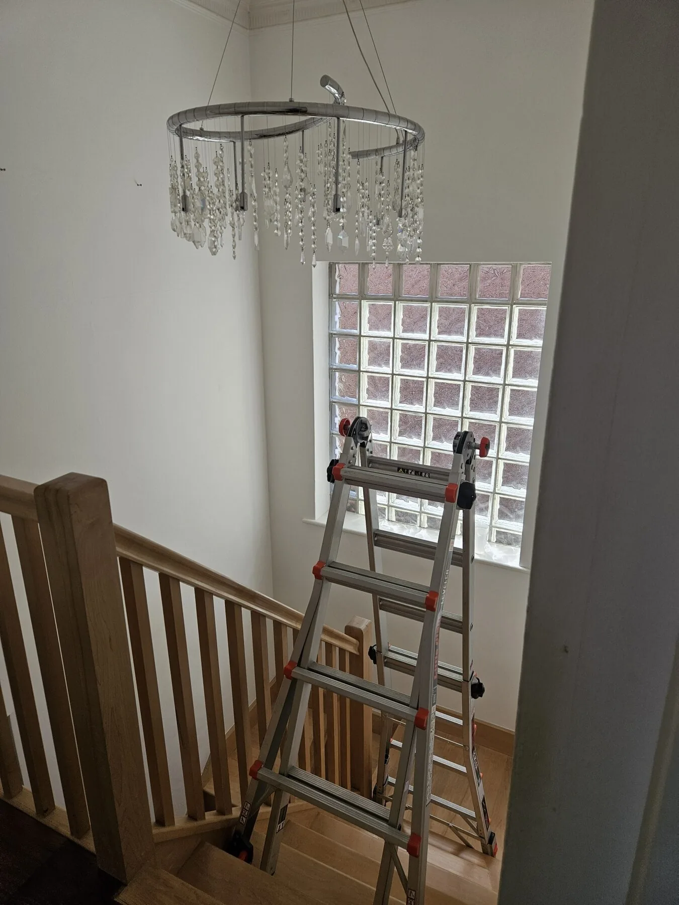 Chrome spiral chandelier above the stairwell in Kent before cleaning