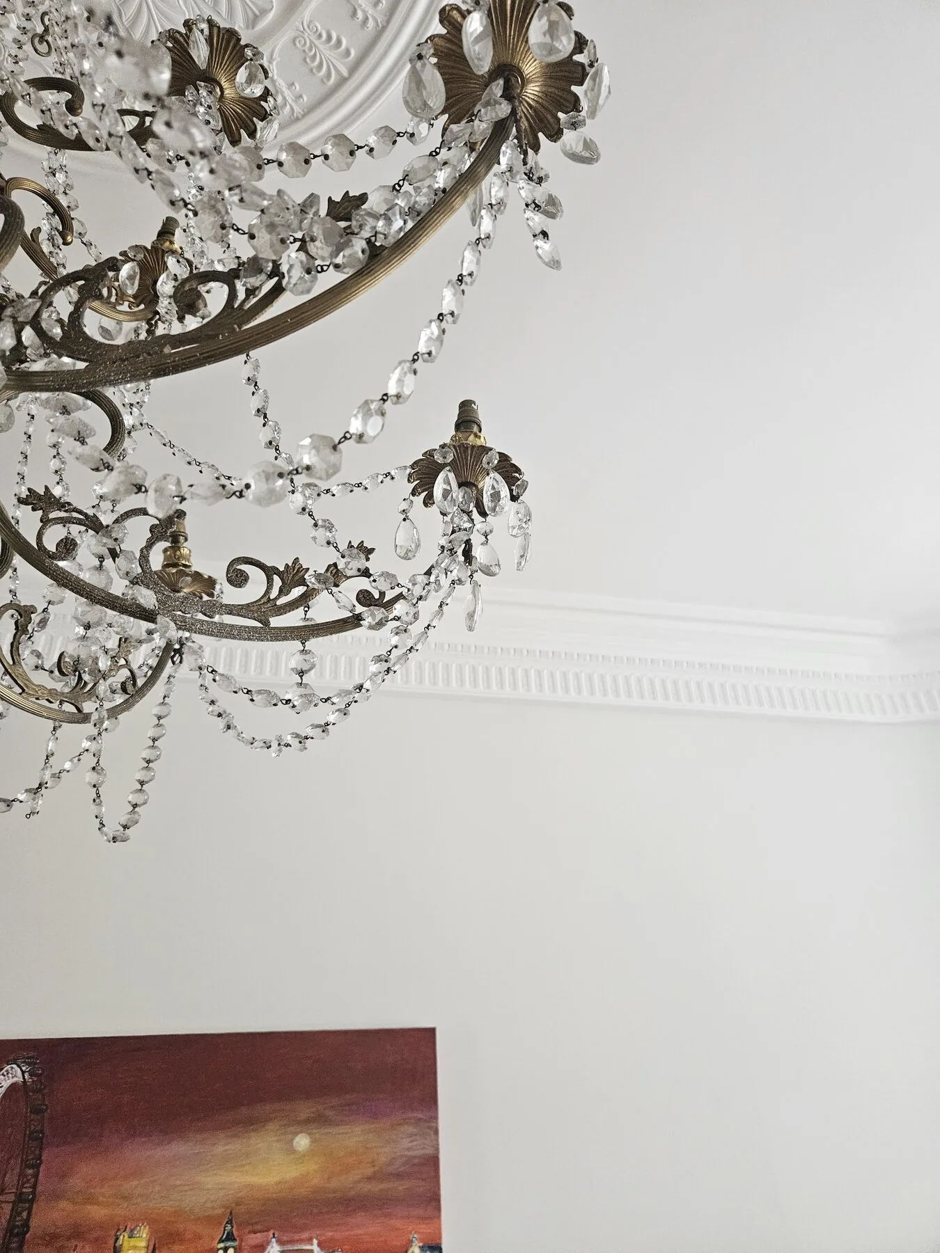 Detail of the ornate brass arms and crystal swags of the Italian chandelier