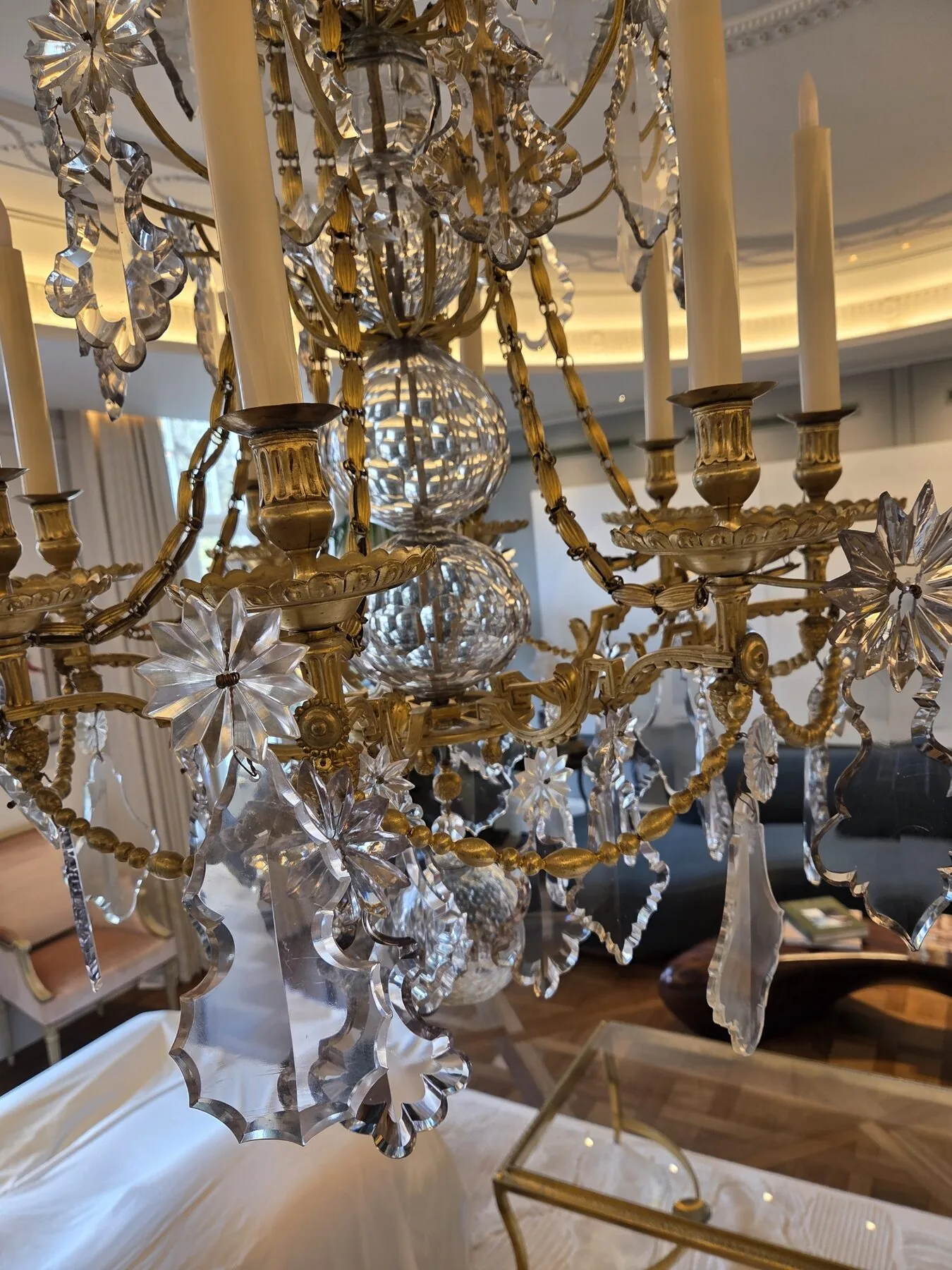 Cut crystal pendalogues and star-form drops on the lower tier of the chandelier
