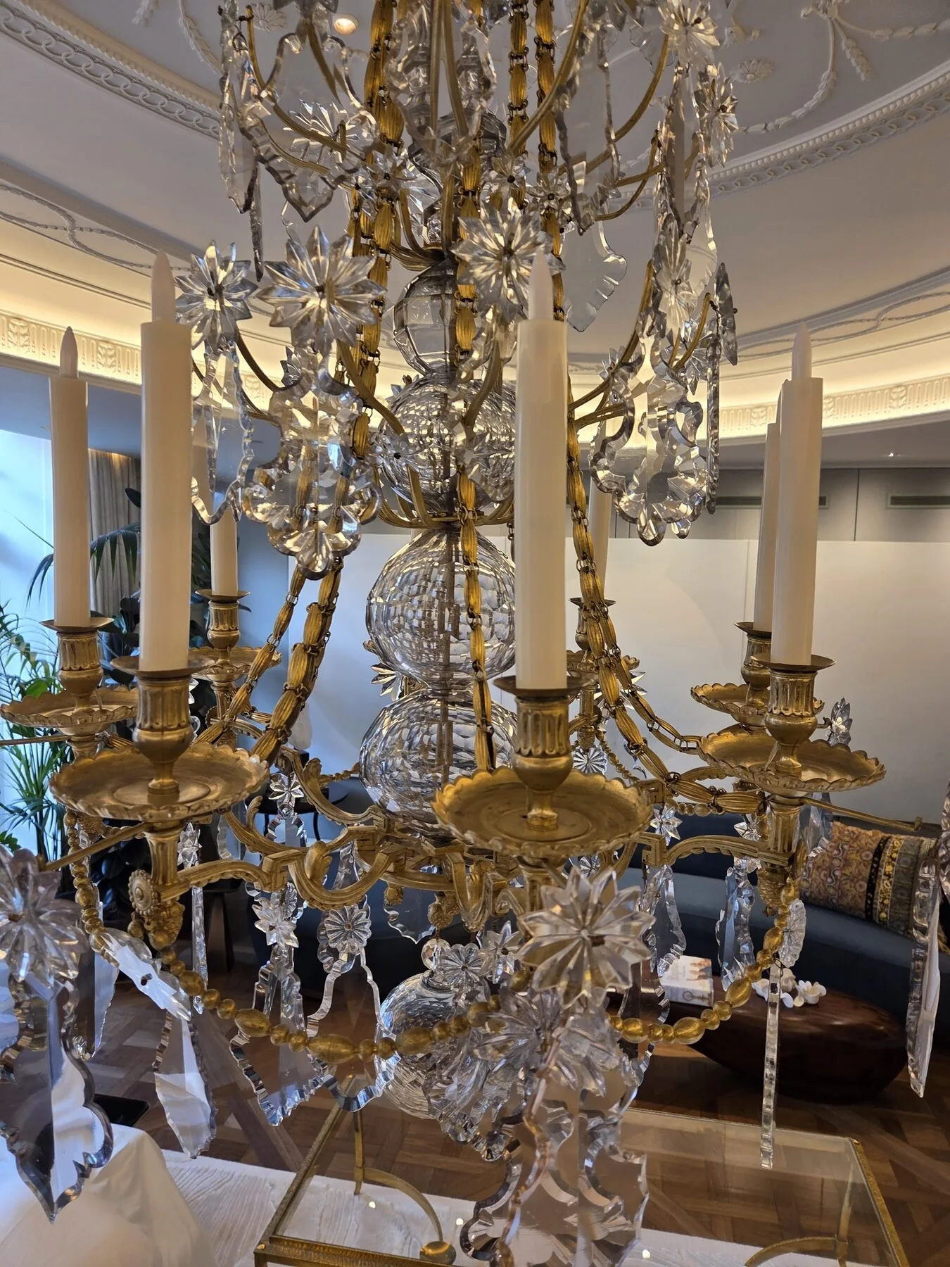 The chandelier viewed from below showing candle cups, arms and crystal dressing