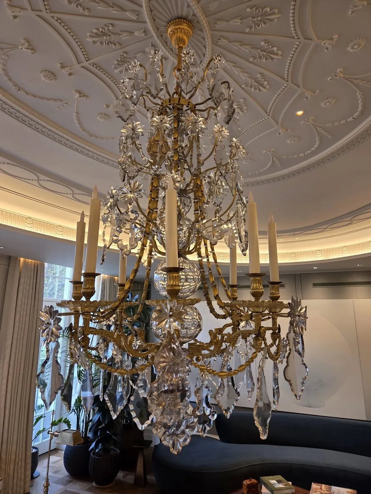 French leaded glass chandelier hanging beneath the ornate plasterwork ceiling of a Mayfair reception room