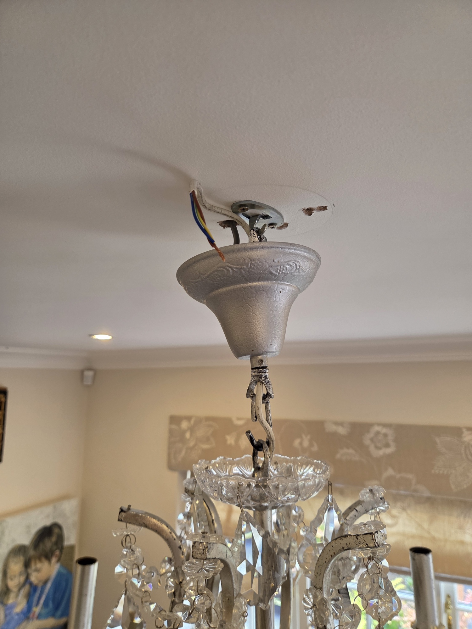 The new steel fixing hook installed in the ceiling with the chandelier hung from it.