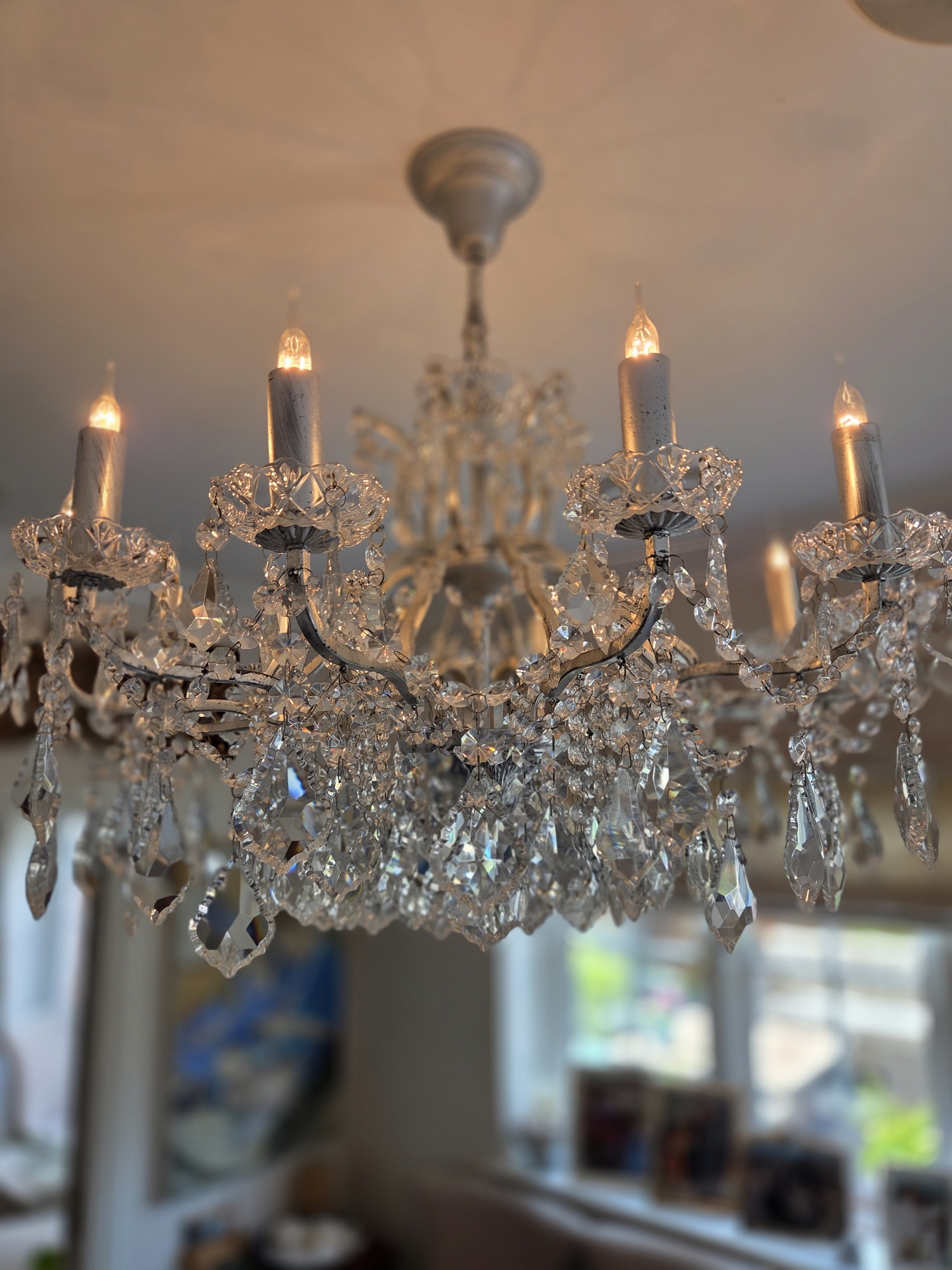 Close view of the repaired chandelier after rehanging, with replacement glass drops fitted.