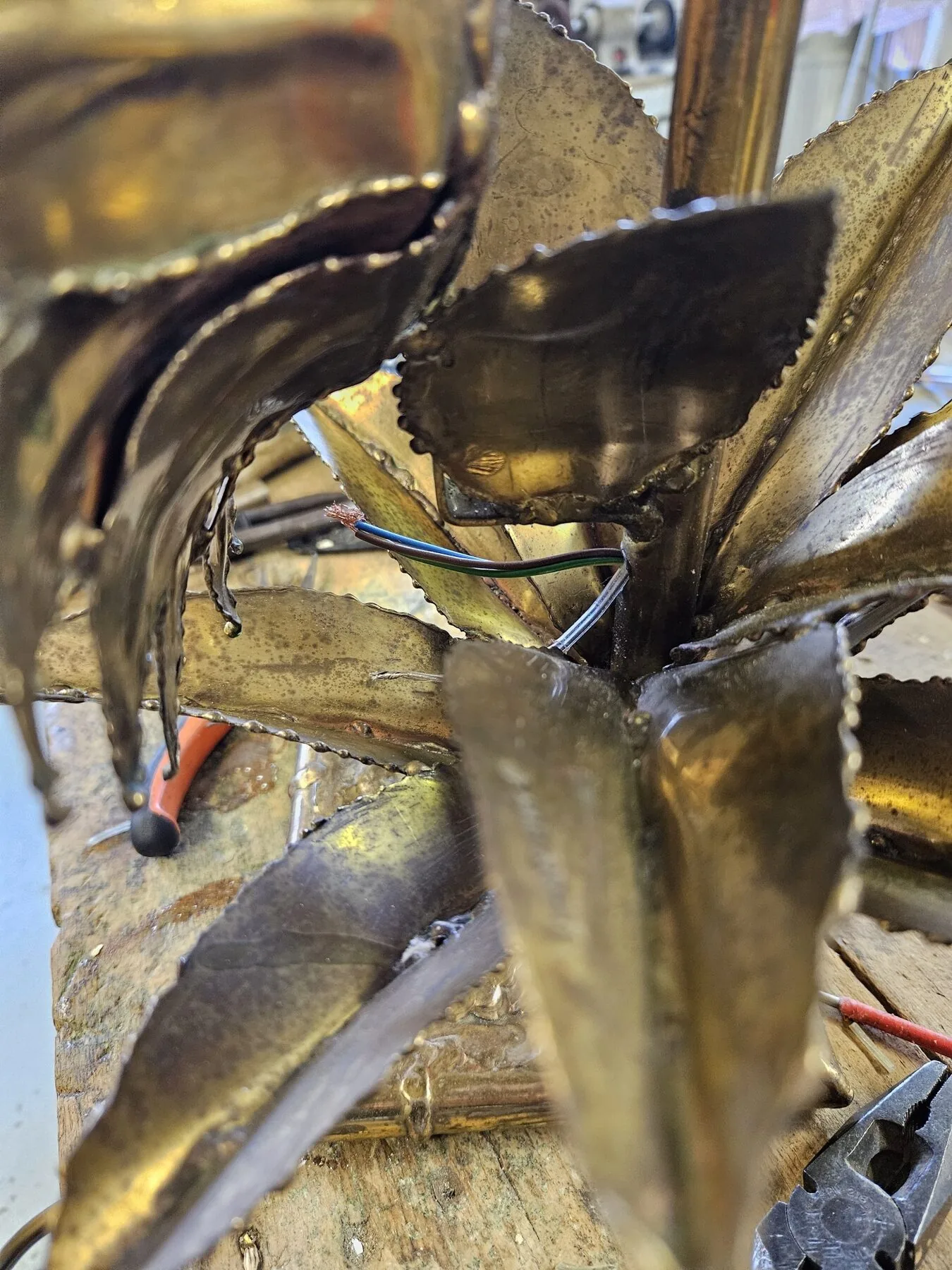 Detail of old wiring running between the brass petals of the sunflower lamp
