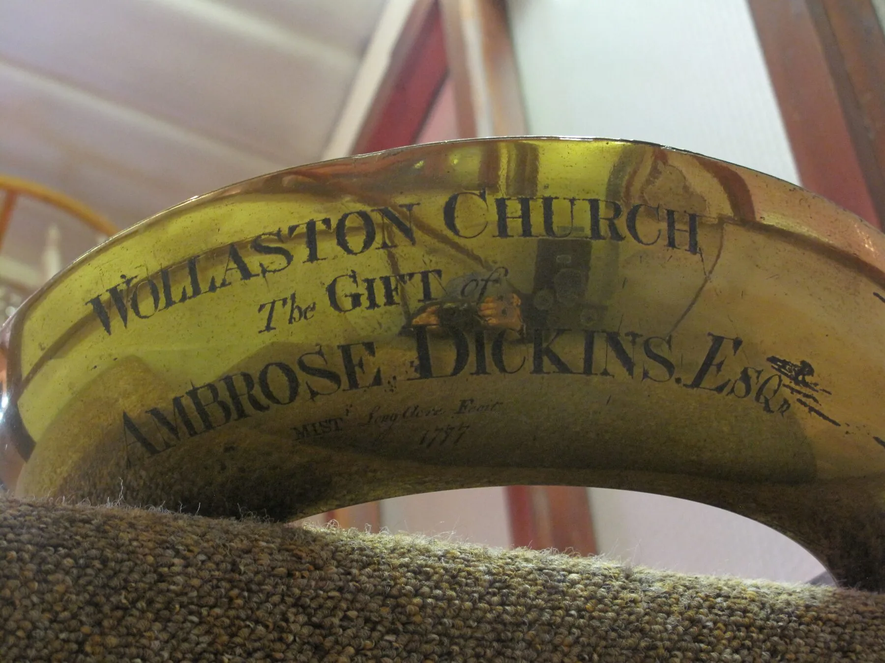 Engraved brass band reading 'Wollaston Church — The Gift of Ambrose Dickins Esqr', dated 1777