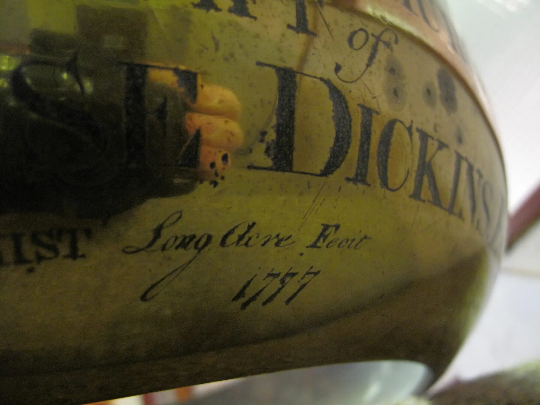 Close detail of the engraved maker's inscription 'Long Acre Fecit 1777' on the brass bowl