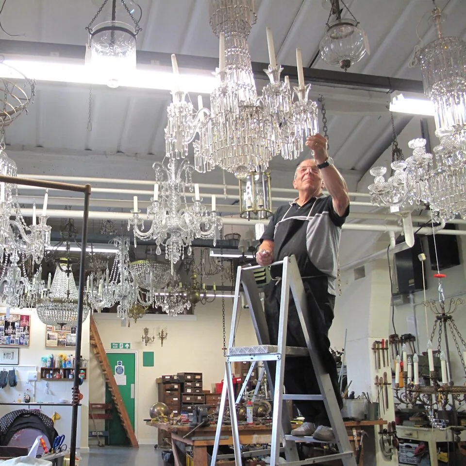 Craftsman working on antique chandeliers in the workshop