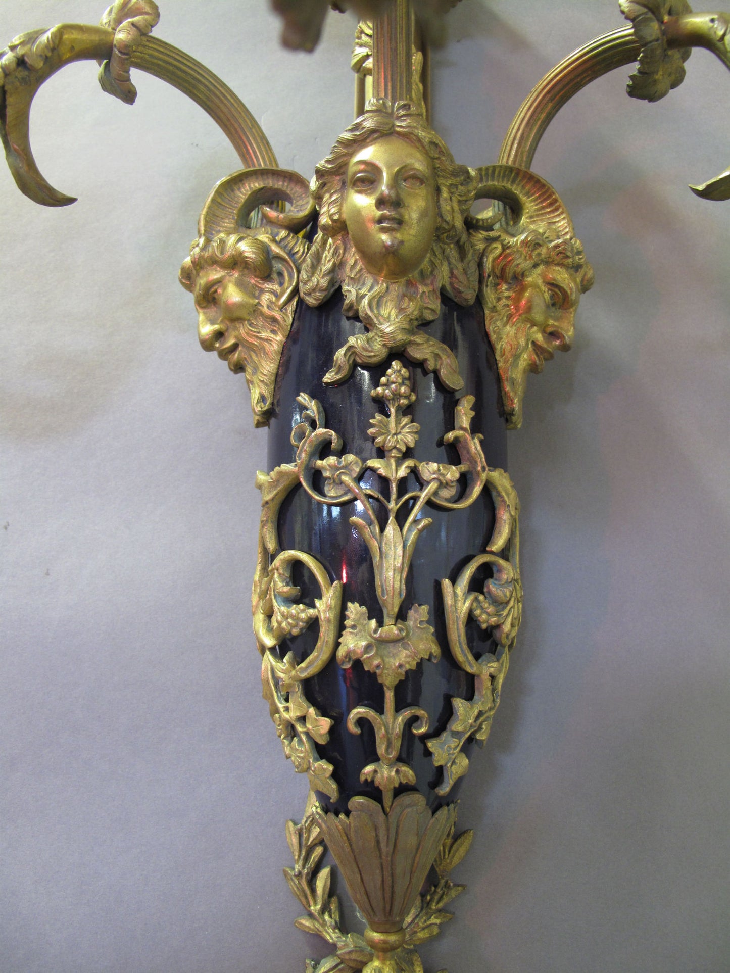 view of 3 heads and floral drapes on centre of wall light